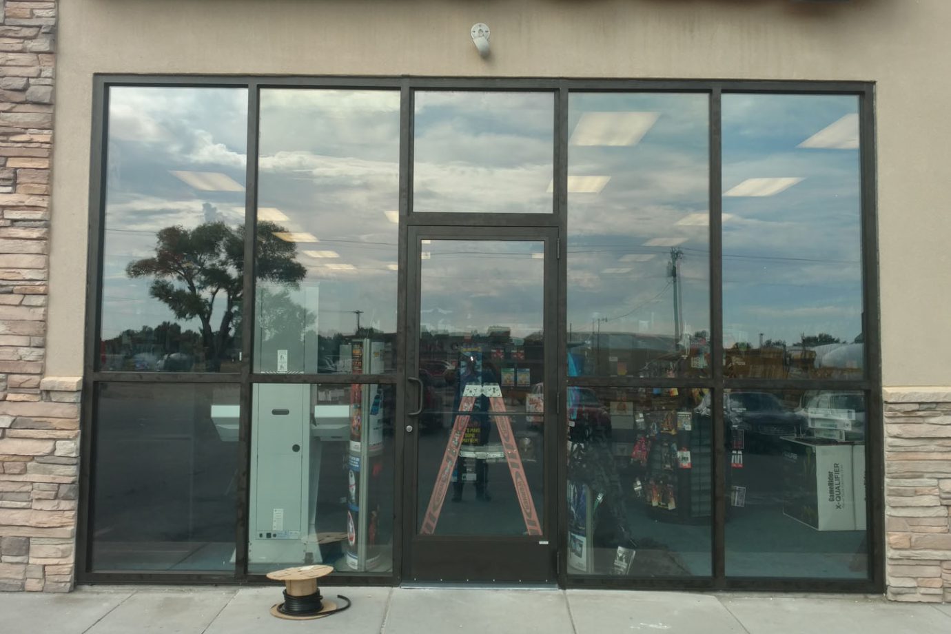 Glass Dooe of the Supermarket beige home exterior with white garage doors